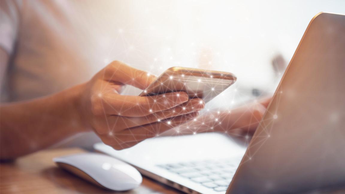 Woman emailing using mobile phone or laptop